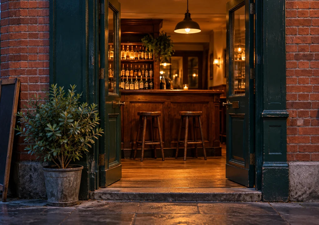 An unbranded pub doorway opening onto a quiet warmly lit interior at dusk